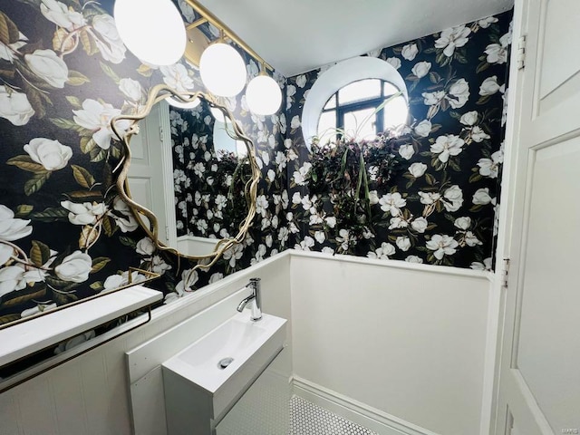 bathroom with vanity and wallpapered walls