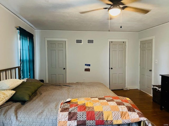 bedroom with visible vents, a ceiling fan, and dark wood-style floors