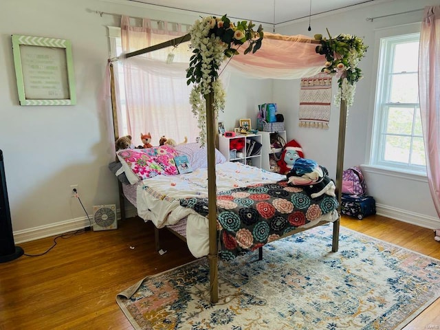 bedroom with wood finished floors and baseboards