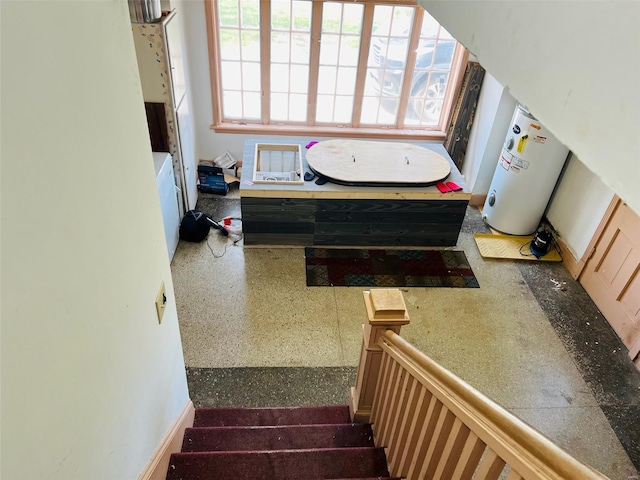 stairs featuring speckled floor and water heater