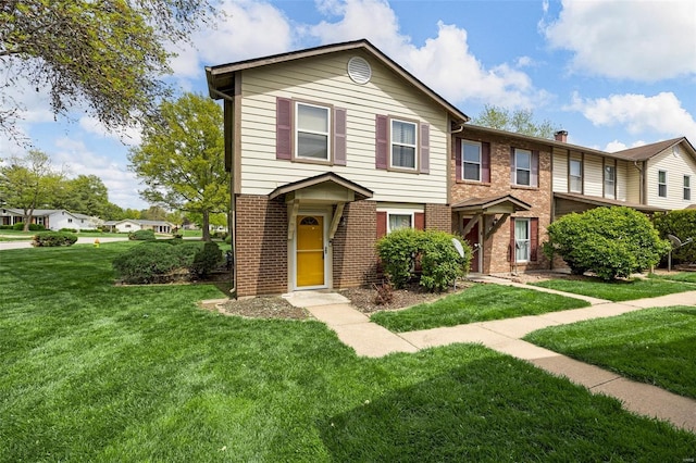 multi unit property featuring a front lawn, a chimney, and brick siding