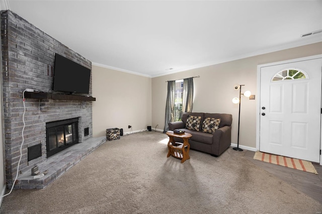 carpeted living room with a fireplace, crown molding, visible vents, and baseboards