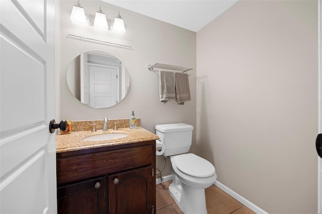 bathroom with baseboards, tile patterned floors, toilet, and vanity