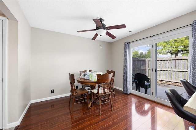 dining room with wood finished floors, baseboards, visible vents, a ceiling fan, and a textured ceiling