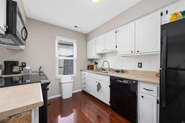kitchen with white cabinets, black appliances, dark wood-style flooring, a sink, and baseboards
