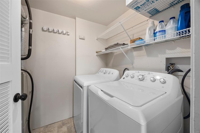 laundry area featuring washing machine and dryer, laundry area, and stone finish flooring