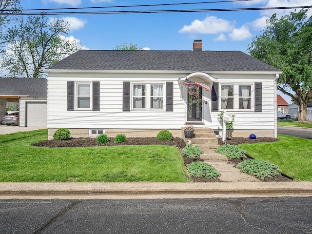 view of front of property with a garage, a front lawn, and a chimney