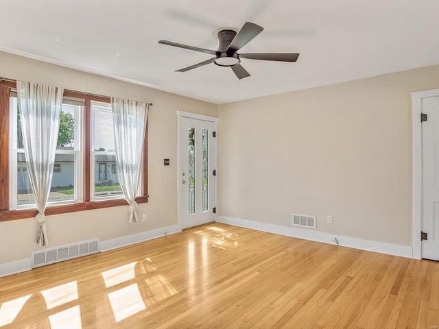 unfurnished room featuring a ceiling fan, baseboards, visible vents, and light wood finished floors