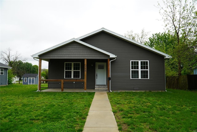 bungalow-style home with fence, covered porch, and a front yard