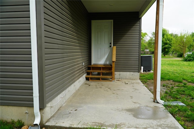 view of exterior entry with a patio area and cooling unit