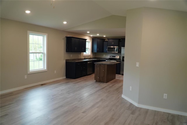 kitchen with a kitchen island, stainless steel appliances, a wealth of natural light, and lofted ceiling