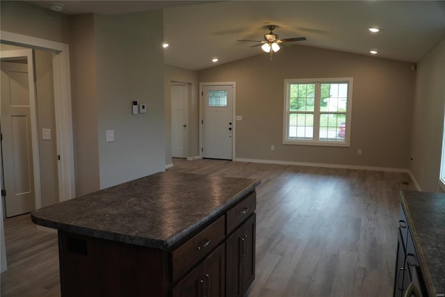 interior space with a ceiling fan, dark countertops, dark brown cabinets, and light wood-style floors