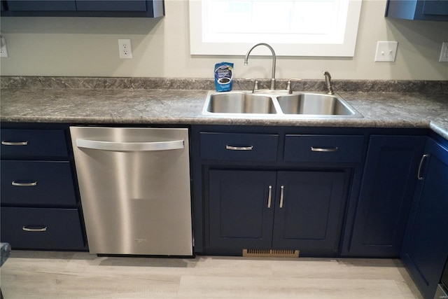 kitchen featuring a sink, light wood-style floors, blue cabinets, and dishwasher