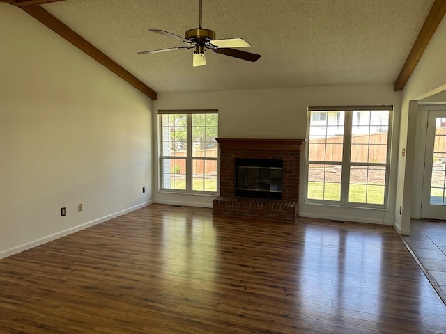 unfurnished living room featuring a ceiling fan, dark wood-style flooring, a textured ceiling, vaulted ceiling, and baseboards