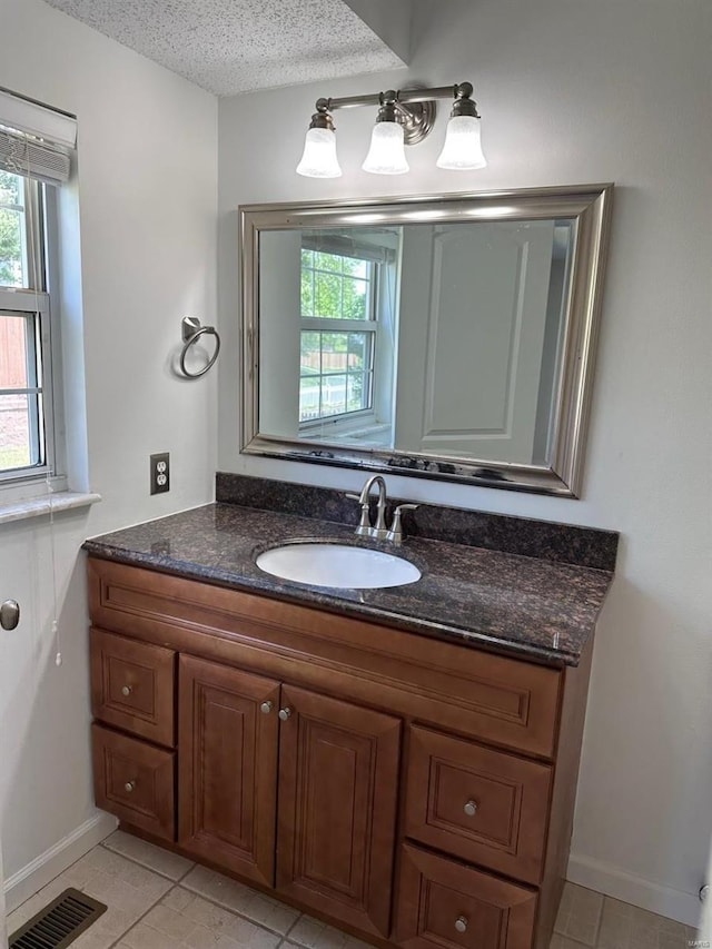 bathroom featuring visible vents, a healthy amount of sunlight, and tile patterned flooring