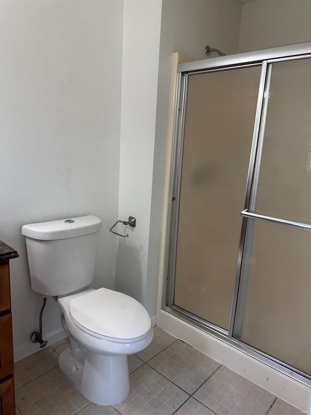 full bathroom featuring vanity, a stall shower, baseboards, and tile patterned flooring