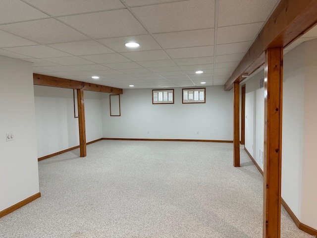 below grade area with baseboards, recessed lighting, a paneled ceiling, and light colored carpet