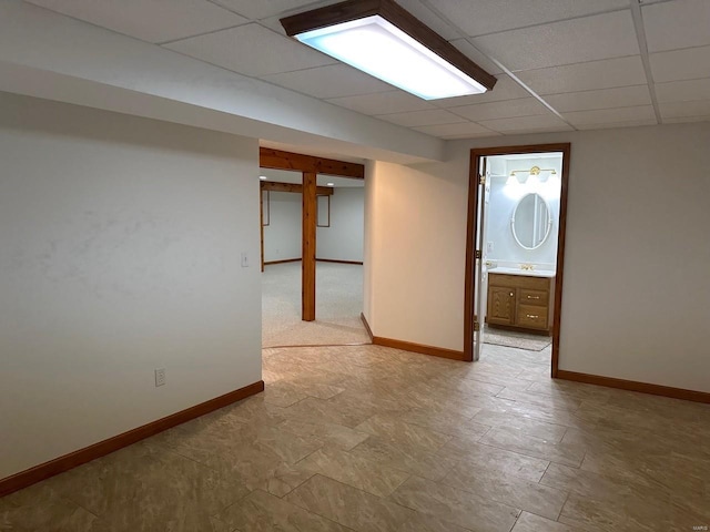 spare room with baseboards and a drop ceiling