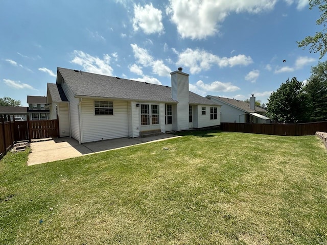 rear view of property with fence, a patio, roof with shingles, a chimney, and a yard