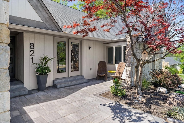 property entrance with french doors, a patio, and a shingled roof