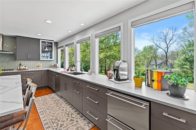 kitchen with a sink, stainless steel appliances, decorative backsplash, glass insert cabinets, and a warming drawer