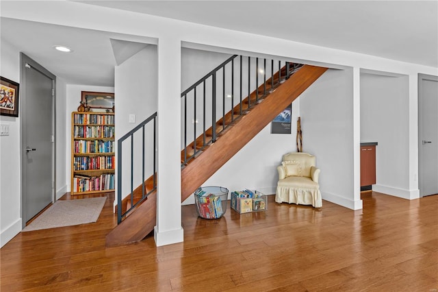 staircase featuring baseboards, recessed lighting, and wood finished floors