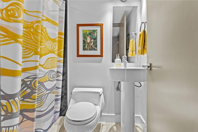 full bath featuring baseboards, curtained shower, and toilet