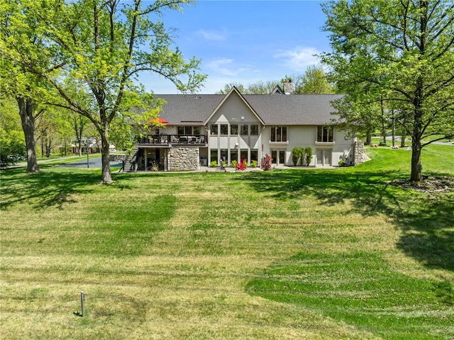 back of house with a wooden deck, stairs, a chimney, and a yard