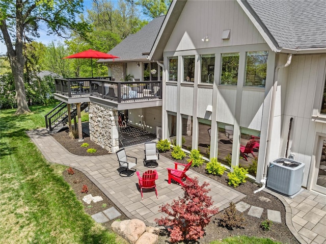 rear view of house with stairway, cooling unit, a patio area, and roof with shingles