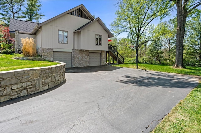 view of property exterior with driveway, stairs, stone siding, and a garage
