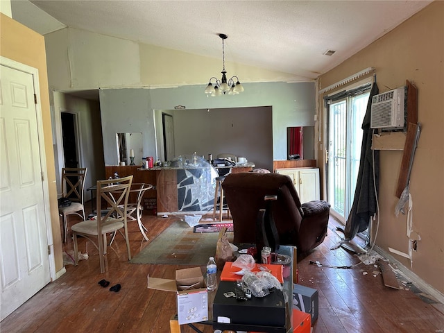 dining space with a chandelier, baseboards, lofted ceiling, a wall mounted AC, and hardwood / wood-style flooring