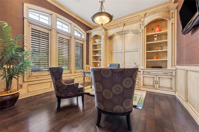 sitting room featuring visible vents, crown molding, built in features, a decorative wall, and dark wood-type flooring