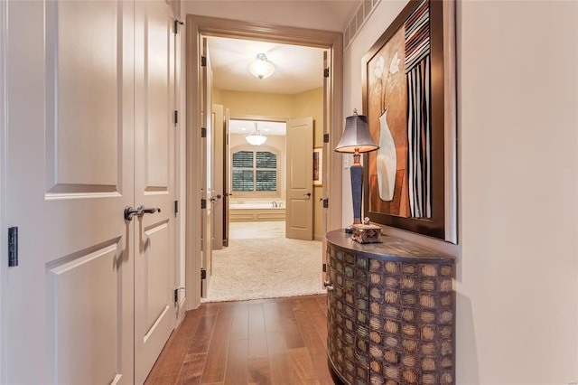 hallway with visible vents and dark wood-style flooring