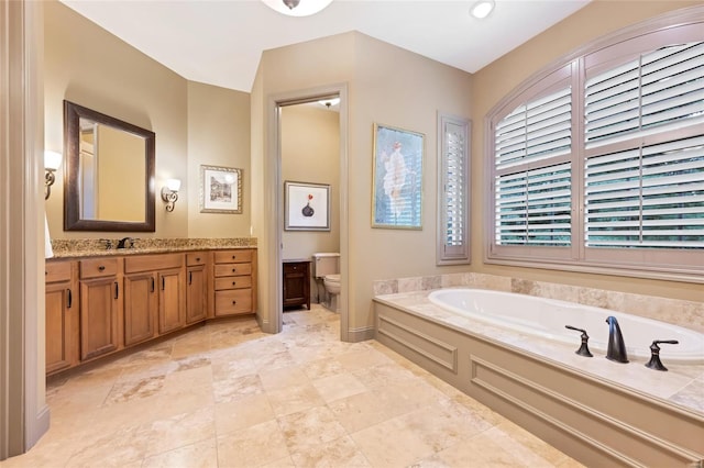 bathroom featuring toilet, a garden tub, and vanity