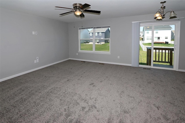 empty room with ceiling fan with notable chandelier, baseboards, and a healthy amount of sunlight