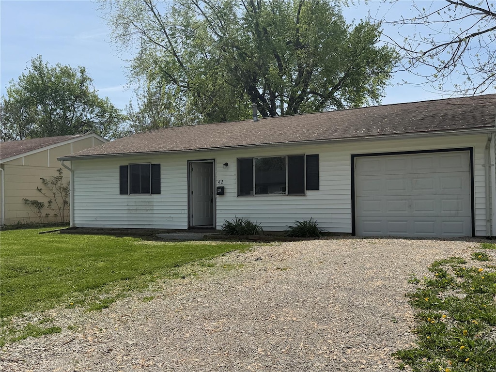 ranch-style home featuring gravel driveway, a front lawn, roof with shingles, and a garage