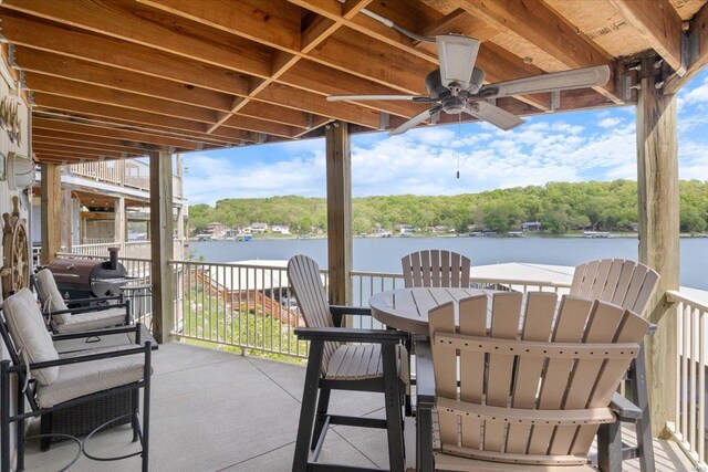 view of patio with a water view, ceiling fan, and grilling area