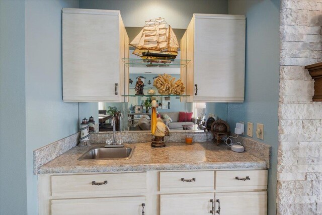 kitchen featuring white cabinetry and a sink