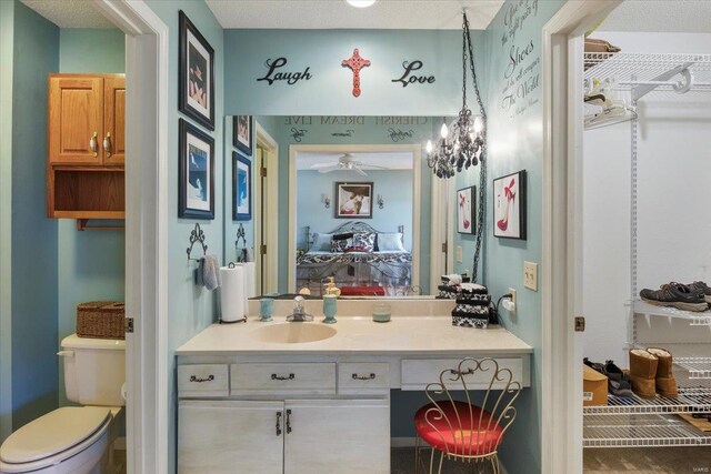 bathroom featuring vanity, ceiling fan, and toilet