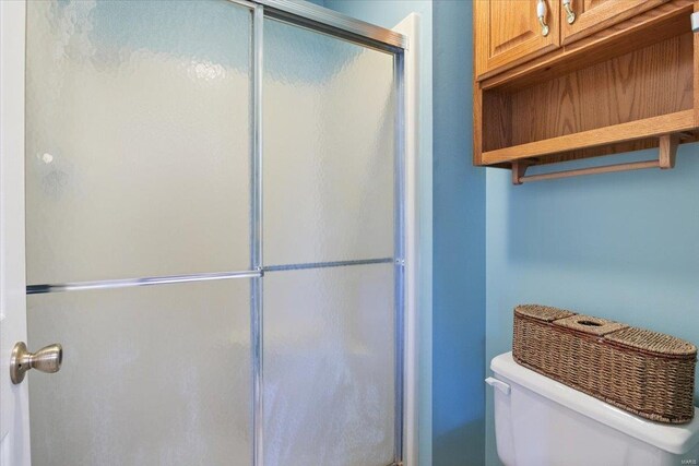 full bathroom with toilet and a shower stall