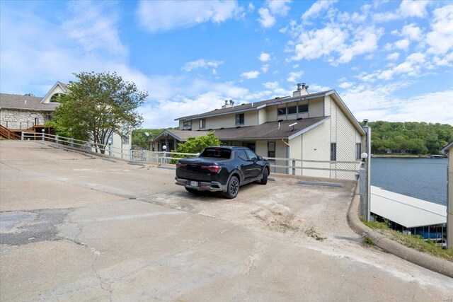 view of front of home featuring fence, uncovered parking, and a chimney