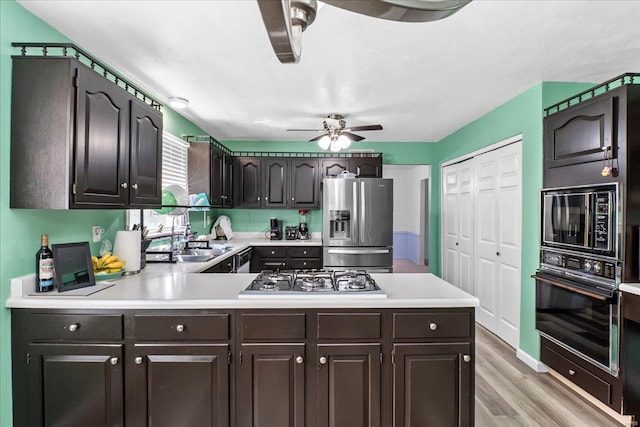 kitchen with black appliances, a ceiling fan, a sink, and light countertops