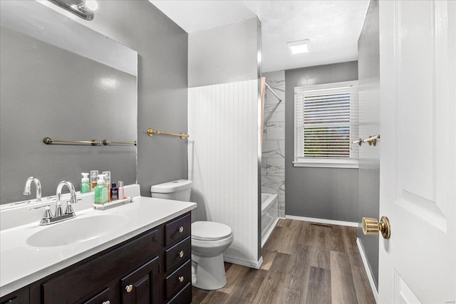full bath with shower / washtub combination, wood finished floors, toilet, vanity, and baseboards