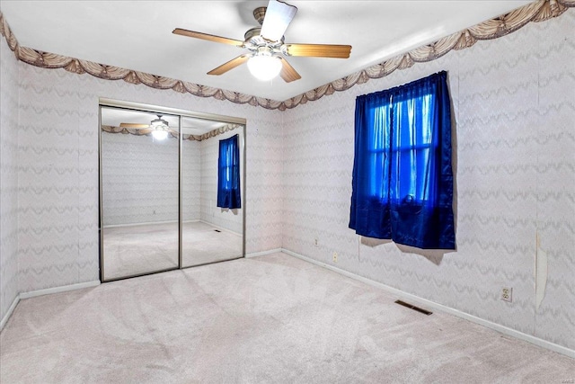 unfurnished bedroom with visible vents, carpet flooring, baseboards, and a ceiling fan
