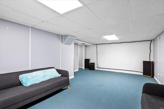 carpeted cinema with a paneled ceiling and baseboards