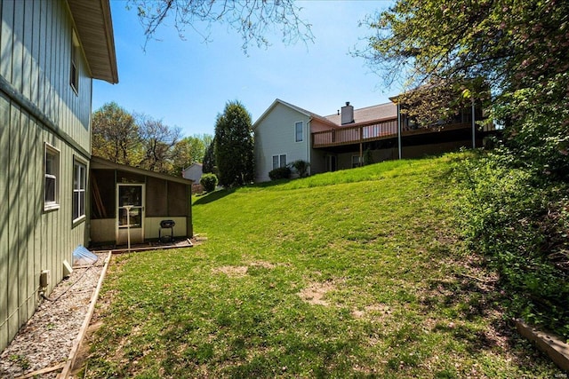 view of yard with a sunroom and a deck
