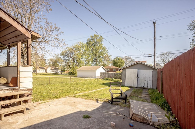 view of yard with a fenced backyard, a patio, an outbuilding, and a shed