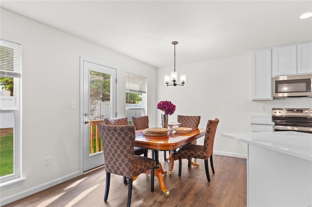 dining space featuring baseboards, recessed lighting, wood finished floors, and a chandelier