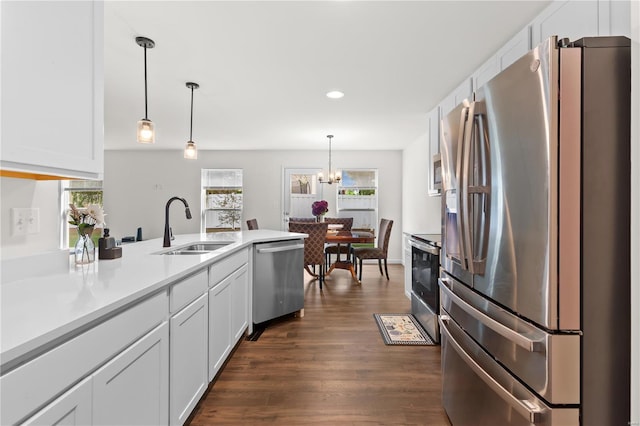 kitchen featuring a peninsula, recessed lighting, white cabinets, a sink, and stainless steel appliances