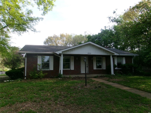 view of front of house featuring a front lawn, brick siding, and a porch